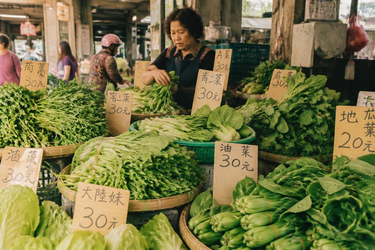 台灣傳統市場的青菜攤，竹籃裝滿各種青菜與手寫價錢牌
